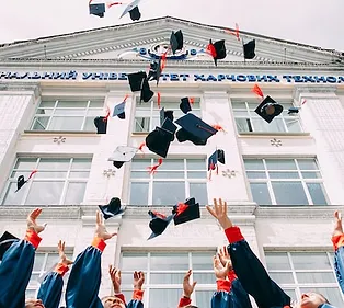 graduates throwing their caps up in the air